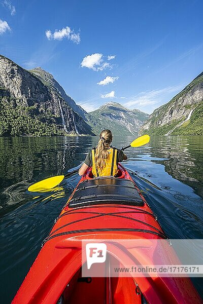 Junge Frau paddelt in einem Kajak  Geirangerfjord  bei Geiranger  Norwegen  Europa