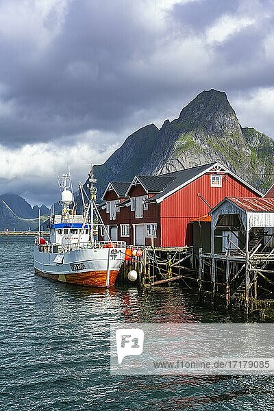 Rorbuer  typische Holzhäuser  Fischerboot im Hafen  Reine  Moskenesöy  Lofoten  Nordland  Norwegen  Europa