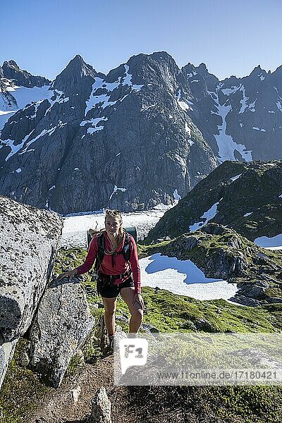 Junge Frau beim Wandern  Berge und Schnee  Wanderung zur Trollfjord Hytta  am Trollfjord  Lofoten  Nordland  Norwegen  Europa