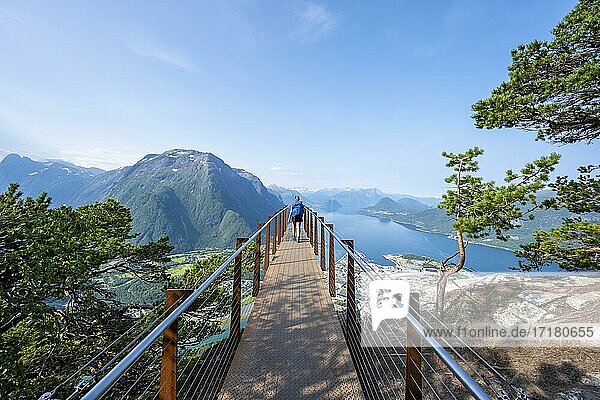 Wanderin steht auf Aussichtsplattform Rampestreken  Wanderung Romsdalseggen  Fluss Rauma  Romsdalfjellene-Berge  Andalsnes  Møre og Romsdal  Norwegen  Europa