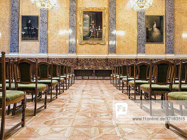 A large room with rows of chairs and chandeliers, part of the Museum of Fine Arts in Budapest