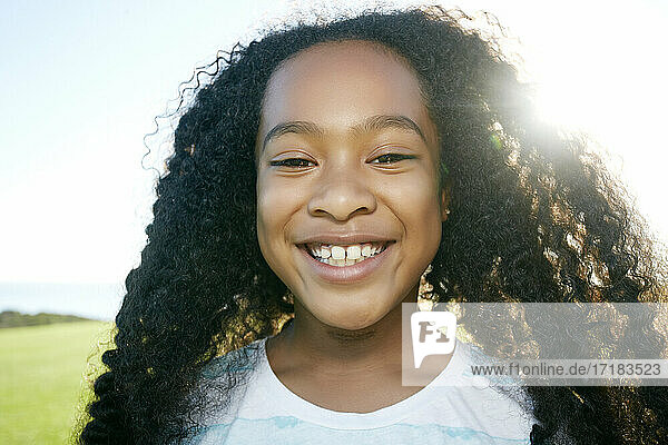 Junge gemischte Rasse Mädchen mit langen lockigen schwarzen Haaren  lächelnd