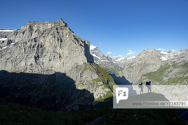 Zwei Wanderer bewundern die Berge während der Wanderung zur Muttsee-Hütte auf dem Kalktrittli-Weg  Kanton Glarus  Schweiz  Europa