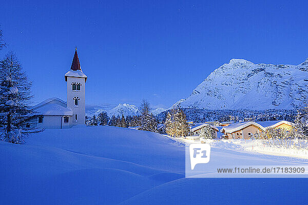 Alpendorf Maloja und Chiesa Bianca mit Schnee bedeckt in der Abenddämmerung  Bergell  Engadin  Kanton Graubünden  Schweiz  Europa