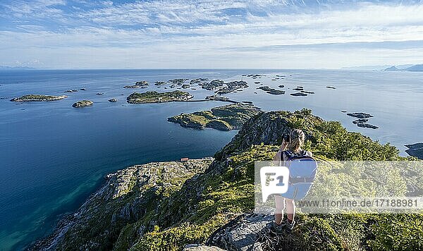 Houses on small rocky islands in the sea  hiker looking down on Henningsvær from the top of Festvågtind mountain  Vågan  Lofoten  Nordland  Norway  Europe