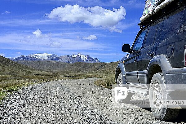 Off-road vehicle  Land Cruiser  on the gravel road Carretera a Pastoruri  in the back mountain range with Nevado Tuco  Cordillera Blanca  province Recuay  Peru  South America