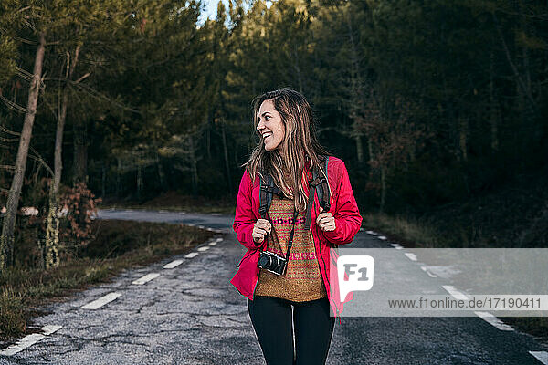 Lächelndes Mädchen mit Rucksack in der Natur zu Fuß durch den Wald. Entspannung Zeit im Urlaub Konzept Reisen  selektive und weichen Fokus  Hipster-Stil Farbton