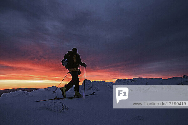 backcountry skier at vivid red sunrise  Mount Washington  NH