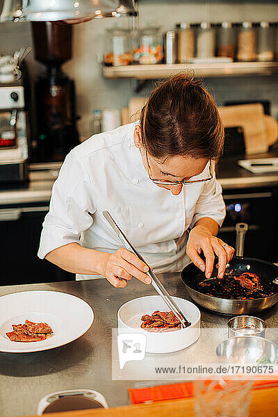 Michelin-Koch serviert Essen auf einem Teller  während er im Restaurant arbeitet