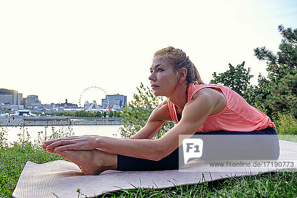 Weibliche Athletin macht Yoga-Bewegung im Park