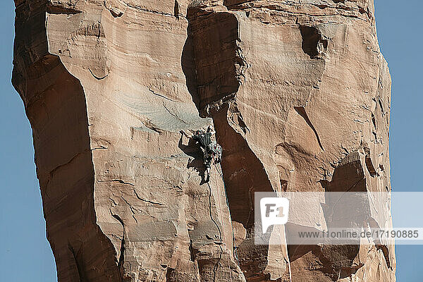 Rückansicht eines Mannes  der eine Felsformation im Canyonlands National Park erklimmt