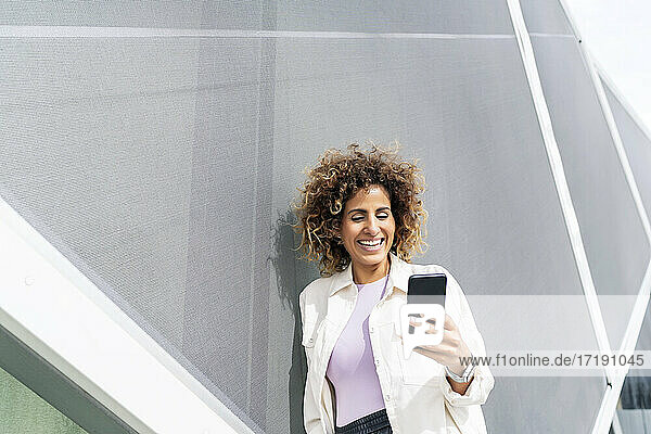 schöne Frau lächelt  während sie über ihr Smartphone spricht