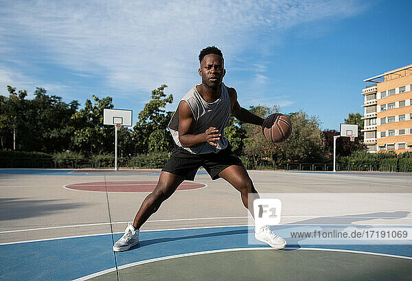 Afroamerikanischer Sportler dribbelt Basketball