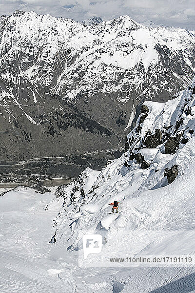 Mann beim Snowboarden auf einem schneebedeckten Berg im Urlaub
