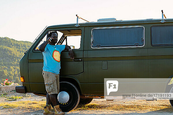 black african american man talking on the phone in his camper van