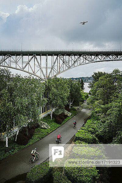 Luftaufnahme von Radfahrern auf dem städtischen Radweg mit Brücke in der Ferne