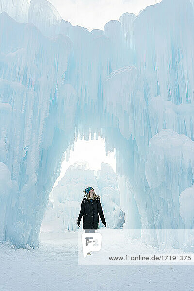 Fröhliche junge Frau beim Spaziergang in Eisschlössern