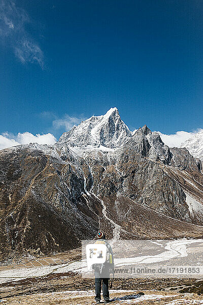 Mann steht vor einem schneebedeckten Berg  HImalayas  Nepal