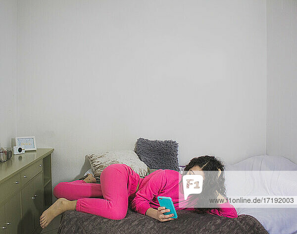 Frau im Bett mit Blick auf soziale Medien auf dem Handy