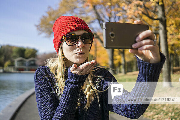 Kanadische Frau macht im Park ein Selfie mit ihrem Smartphone