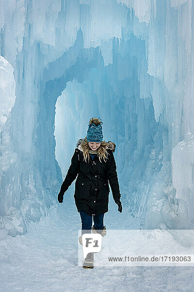 Lächelnde junge Frau beim Spaziergang in Eisschlössern