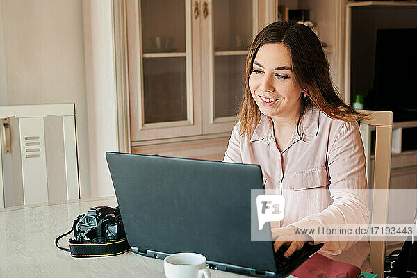 Young woman works from home on her laptop