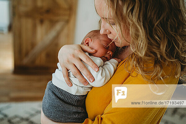 Nahaufnahme der schönen blonden Mutter hält neugeborenes Baby in ihren Armen
