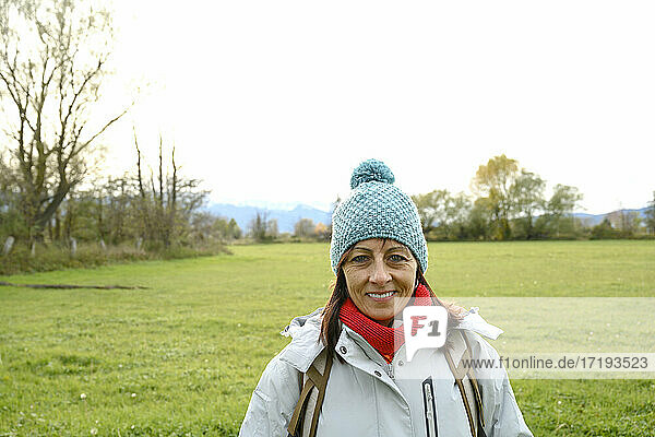 Porträt einer lächelnden Backpacker-Frau mit Wollmütze  die in die Kamera schaut