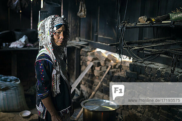 Frau vom Stamm der Akha steht in ihrem Haus in der Küche  in der Nähe von Kengtung  Myanmar