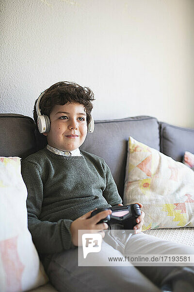 Junge mit Kopfhörern spielt sehr gerne Videospiele. Heimunterhaltung
