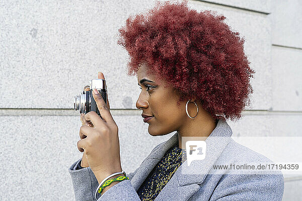 schöne Frau mit Afro-Haar  die Bilder mit ihrer alten Kamera macht