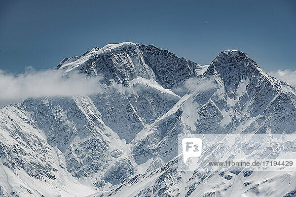 Idyllische Aufnahme eines schneebedeckten Berges vor blauem Himmel
