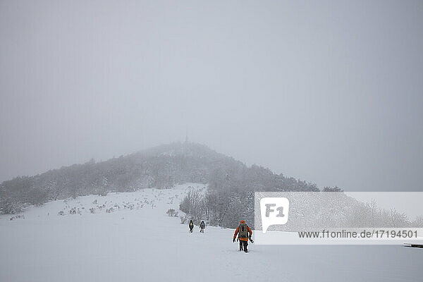 drei Personen überqueren ein völlig verschneites Feld