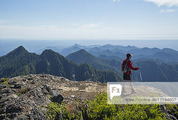 A man climbs a mountain in the Colonel Bob Wilderness on the Olympic Peninsula  WA.