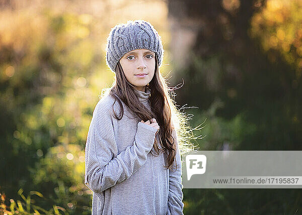 Schönes junges Mädchen in Pullover und Hut im Freien im Herbst.