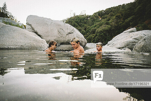 Drei Jungen entspannen sich in einem Wasserbecken in der Abenddämmerung