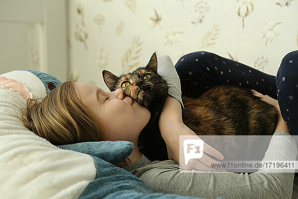 Kind küsst eine Katze. Mädchen und Katze in Großaufnahme.