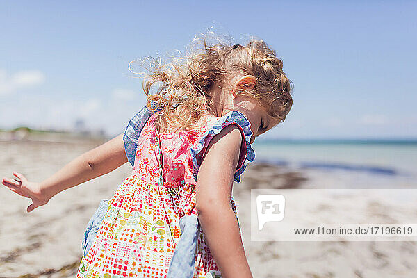 Preschooler girl playing on the beach.