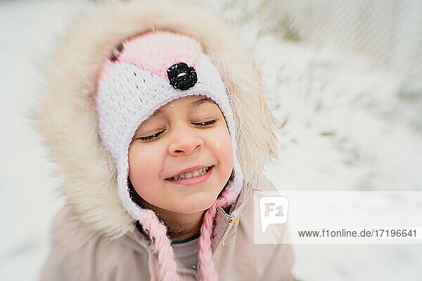 Junges Mädchen Kind glücklich im Schnee lächelnd