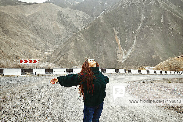 Woman having fun on the mountain road