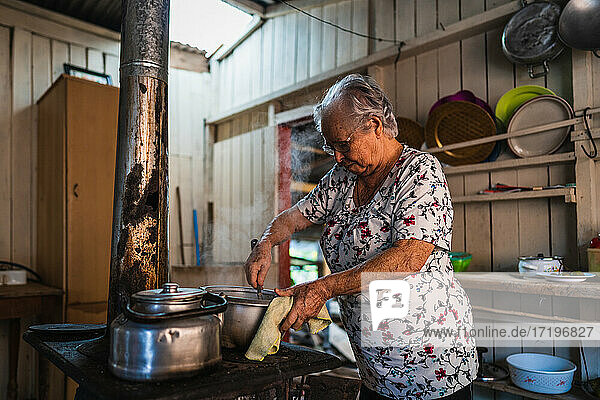 Ältere Frau kocht auf einem alten Retro-Herd