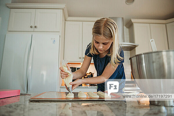 Junges Mädchen backt Macarons in der Küche
