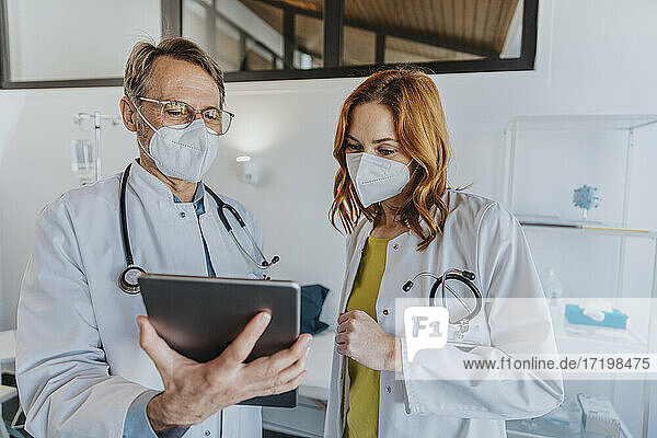 Mitarbeiter des Gesundheitswesens arbeiten in der Klinik gemeinsam an einem digitalen Tablet