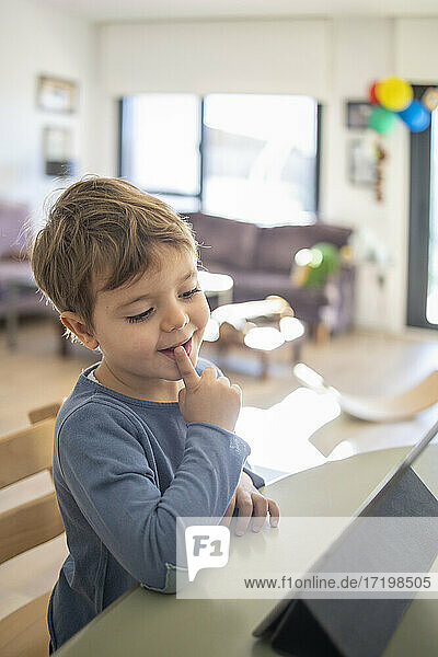 Boy using digital tablet during online class at home