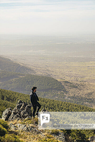 Male hiker looking at view while standing on rock at Somosierra  Madrid  Spain