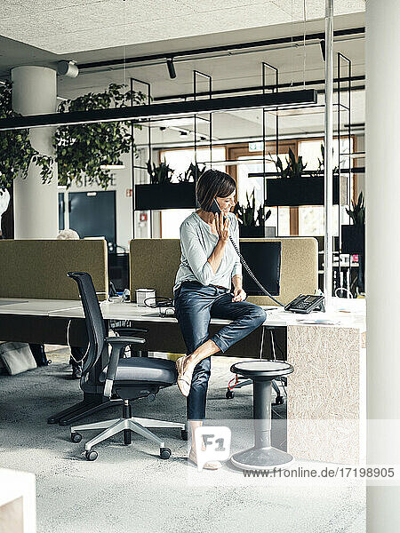 Weibliche Unternehmerin beim Telefonieren im Büro