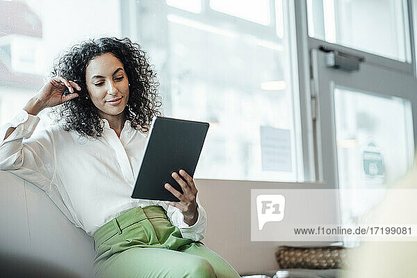 Junge Geschäftsfrau  die ein digitales Tablet benutzt  während sie in einem Café sitzt