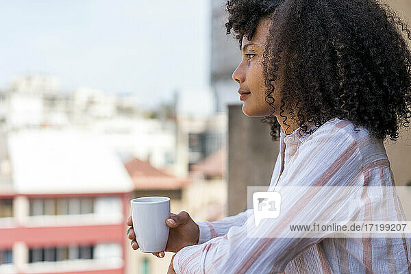 Nachdenkliche Unternehmerin auf dem Balkon während der Kaffeepause im Büro