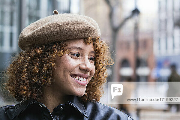 Smiling teenage girl wearing beret looking away while standing outdoors