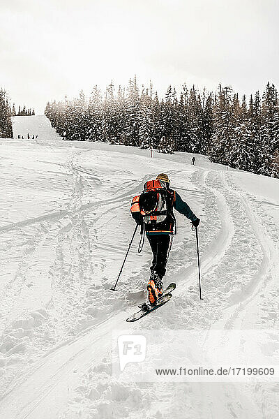 Kaukasischer älterer Mann beim Skifahren auf Schnee im Urlaub